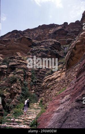Homme marchant dans une rue en pierre de Shibam Kawkaban à la forteresse-ville de Kawkaban, gouvernorat d'Al Mahwit, Yémen Banque D'Images