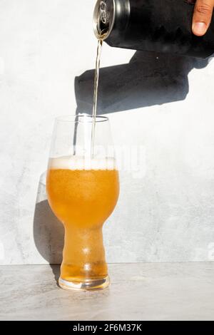 Sert de la bière, d'une canette à un verre de cristal pour IPA Banque D'Images