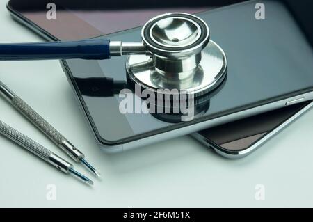 Stéthoscope, smartphone, tablette et tournevis. Concept de réparation et de service de smartphone. Concept un état de santé de l'appareil. Banque D'Images