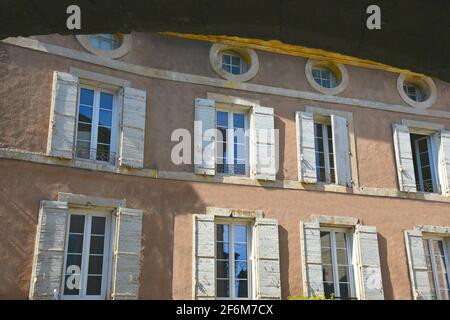 Façade de maison rurale de style provençal avec un mur en stuc ocre et des volets en bois blanc antique à Bonnieux Vaucluse, Provence-Alpes-Côte d'Azur France Banque D'Images