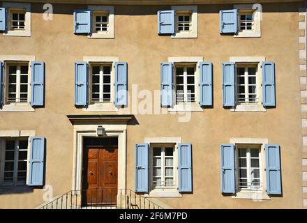 Façade de maison rurale de style provençal avec un mur en stuc ocre et des volets en bois bleu clair à Bonnieux Vaucluse, Provence-Alpes-Côte d'Azur France. Banque D'Images