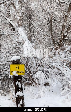 Wheat Ridge, Colorado - UN panneau « no intrusion » le long d'un sentier public près de Clear Creek dans la banlieue de Denver après une chute de neige. Banque D'Images
