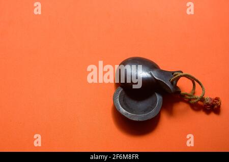 Gros plan de quelques castanets traditionnels en bois sombre de musique espagnole sur fond orange avec espace de copie Banque D'Images