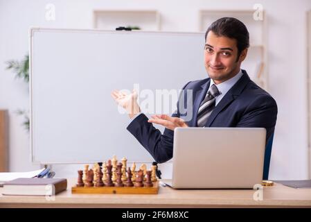 Un jeune homme d'affaires joue aux échecs sur le lieu de travail Banque D'Images