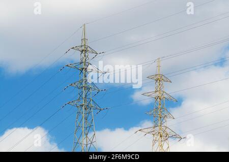 Vue sur deux tours de transmission électrique haute tension contre un Ciel nuageux en Suisse Banque D'Images