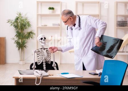 Squelette de cigarette dépendance patient visitant le vieux médecin mâle Banque D'Images