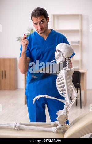 Jeune médecin et patient squelette dans le concept d'antimoking Banque D'Images