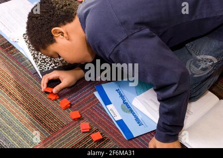 École élémentaire indépendante 4 ans 9-10 mathématiques garçon travaillant avec des manipulations Banque D'Images