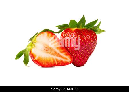 Deux fraises grecques isolées sur fond blanc. Fraise d'Espagne mûre fraîche et biologique et moitié coupée en tranches Banque D'Images