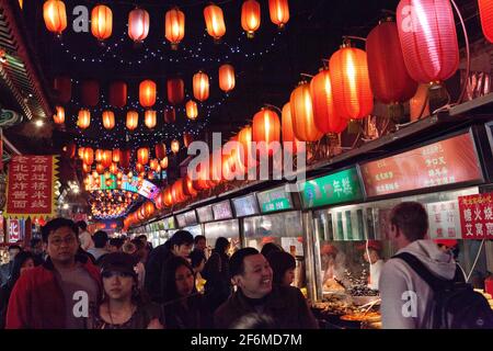 Chine les visiteurs de Beijing marchent à côté des bellicistes au marché de nuit de Donghuamen, situé à l'extrémité nord de Wangfujing. Banque D'Images