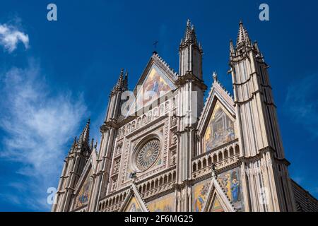 Le magnifique Duomo d'Orvieto, en Ombrie, contre le ciel bleu avec des nuages blancs Banque D'Images