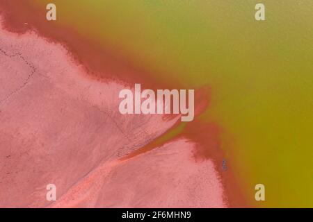Neszmély, Hongrie - vue aérienne de la surface de boue rouge sèche avec lac de couleur verte. Banque D'Images