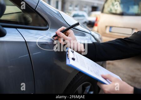 Agent d'assurance ou expert inspectant la voiture après accident Banque D'Images