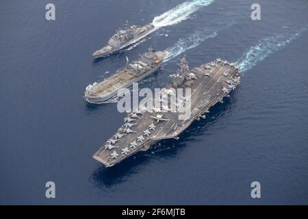 USS Theodore Roosevelt, États-Unis. 31 mars 2021. Le porte-avions USS Theodore Roosevelt, de la classe Nimitz des États-Unis, à droite, est ravitaillé par le navire de la Royal Australian Navy HMAS Sirius, au centre, tandis que le croiseur à missiles guidés de classe Ticonderoga USS Bunker Hill transite à côté lors d'un ravitaillement en mer le 31 mars 2021 sur l'océan Indien. Credit: Planetpix/Alamy Live News Banque D'Images