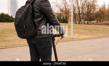 Jeune homme avec sac à dos sur son dos, en scooter Banque D'Images