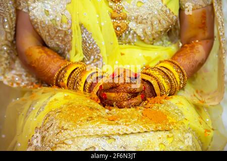 Hindou Bride peint à la main avec de la pâte curcuma fraîche à la veille de son mariage. Banque D'Images