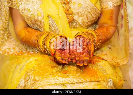 Hindou Bride peint à la main avec de la pâte curcuma fraîche à la veille de son mariage. Banque D'Images