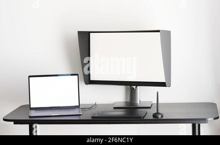 Espace de travail Graphic Designer. Table avec ordinateur portable et moniteur isolée sur fond blanc Banque D'Images
