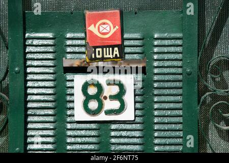 Porte de la vieille maison en métal vieilli avec boîte aux lettres et signe numéro 83, concept urbain, porte verte Banque D'Images
