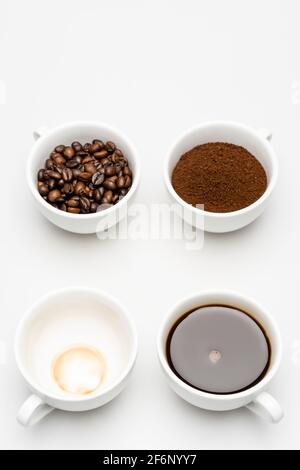 vue de dessus de l'americano préparé près du café moulu et des haricots en tasses sur blanc Banque D'Images