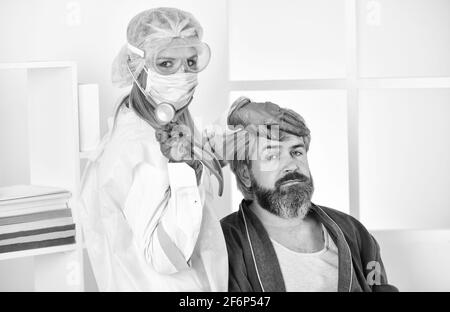 quarantaine du coronavirus. appeler le médecin à la maison. Les risques respiratoires sont courants sur le lieu de travail. L'homme à la maison. Sans contact personnel. Infirmière avec le patient Banque D'Images