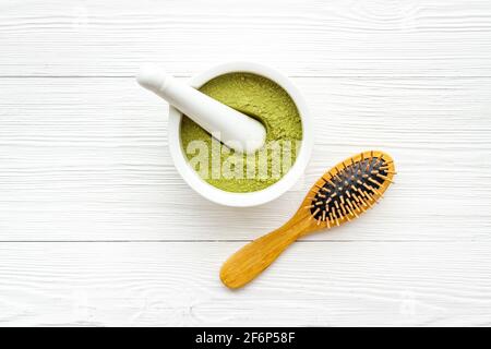 Poudre de teinture pour cheveux de henné et peigne en bois. Henné dans le mortier de wtite Banque D'Images