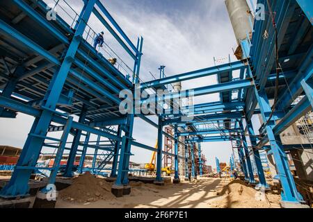 Aktau, Kazakhstan - 19 mai 2012 Construction d'une usine moderne de bitume asphaltique. Structure de construction en acier bleu, tours de distillation grises, grue jaune Banque D'Images