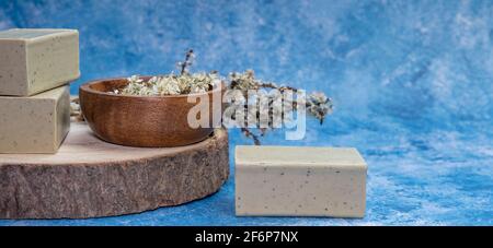 Vue latérale Alep savon et dray Laurus nobilis fleur dans une assiette en bois. Banque D'Images