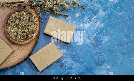 Vue de dessus, le savon d'Alep et le laque Laurus nobilis fleurissent dans une assiette en bois. Banque D'Images