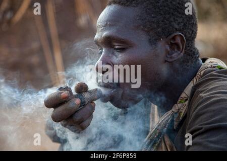 (10/15/2014) les Hadza sont utilisés pour socialiser autour du feu en fumant une pipe ou en jouant des instruments tribaux les Hadza sont un groupe ethnique tanzanien vivant autour du lac Eyasi. La population atteint près d'un millier de personnes; 300-400 vivent comme chasseurs-cueilleurs. Les Hadza n'ont aucune corrélation étroite avec aucune autre population. Ils ont été considérés comme une branche est-africaine du peuple Khoisan, principalement en raison du fait que leur langue a les POP typiques des langues Khoisan, mais des études récentes de recherche génétique suggèrent une proximité avec les Pygmées. Leur langue semble être isolée, sans rapport t Banque D'Images