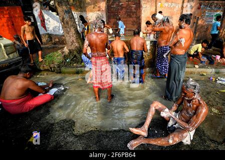 Kolkata, Inde. 02 avril 2021. Les gens ont vu prendre un bain d'un tube d'eau en bord de route bien un matin chaud d'été à Kolkata . Crédit : SOPA Images Limited/Alamy Live News Banque D'Images