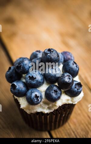 Muffin maison avec bleuets et fromage à la crème sur fond rustique. Mise au point sélective. Banque D'Images