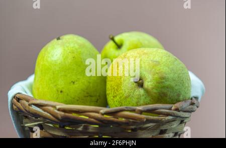 Fruits à la poire verte dans un panier en bois sur fond neutre. Fruit riche en vitamine A, calcium et vitamine C. aliments à faible teneur en calories. Infredient pour les jus et Banque D'Images