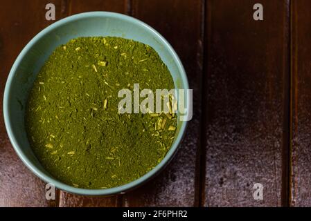 Herbe de maté (Ilex paraguariensis) broyée dans un récipient en céramique à usage culinaire et médicinal. Yerba mate est une plante médicinale largement consommée dans le Sud Banque D'Images