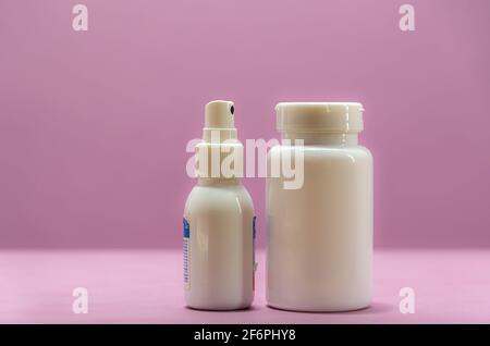 Flacons et pilules en plastique médical sur fond rose. Boîtes à médicaments. Flacons industriels. Médicaments génériques. Banque D'Images