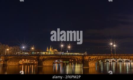 Photo nocturne du pont de la légion - la plupart des Legií - sur la Vltava à Prague, avec le pont Charles et le château de Prague; prise de Slovansky ostrov Banque D'Images