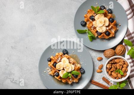 Gaufres belges avec miel, banane, noix et bleuets Banque D'Images