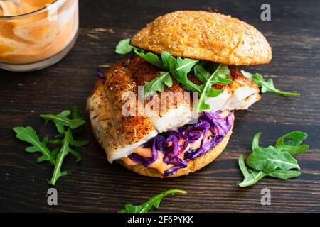 Hamburger au poisson noirci et mayonnaise Sriracha : sandwich au poisson au flétan avec chou rouge et arugula sur un pain de brioche au blé entier Banque D'Images