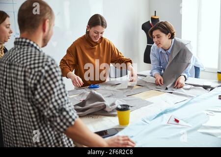Femme tailleur ramasser le motif d'un tas de tissu Banque D'Images