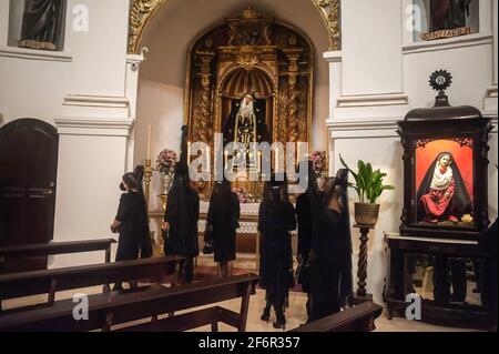 Malaga, Espagne. 02 avril 2021. Les femmes portant des robes de mantilla et des masques faciaux sont vues devant la statue de la Vierge Marie à l'intérieur de l'église Santo Cristo de la Salud comme elles prennent part à un événement social pour promouvoir l'utilisation de la mantilla pendant le jeudi Saint et le Vendredi Saint. Traditionnellement en Espagne, les femmes portent des robes de mantilla comme vêtements de deuil pendant qu'elles accompagnent la Vierge pendant les processions de la semaine Sainte. (Photo de Jesus Merida/SOPA Images/Sipa USA) Credit: SIPA USA/Alay Live News Banque D'Images