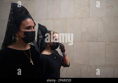 Malaga, Espagne. 02 avril 2021. Les femmes portant des robes de mantilla et des masques de visage marchent dans la rue comme elles prennent part à un événement social pour promouvoir l'utilisation de la mantilla pendant le jeudi Saint et le Vendredi Saint. Traditionnellement en Espagne, les femmes portent des robes de mantilla comme vêtements de deuil pendant qu'elles accompagnent la Vierge pendant les processions de la semaine Sainte. (Photo de Jesus Merida/SOPA Images/Sipa USA) Credit: SIPA USA/Alay Live News Banque D'Images