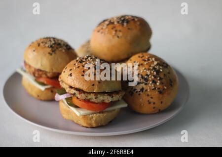 Hamburger au poulet. Préparé par patty de poulet maison, oignons, jalapeno et fromage pris en sandwich à l'intérieur de petits pains à hamburger faits maison. Prise de vue sur fond blanc Banque D'Images