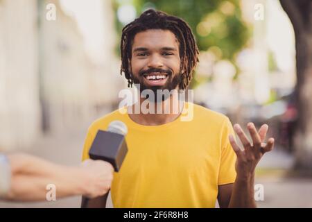 Photo portrait d'un jeune homme souriant donnant une interview à un journaliste parler dans le microphone de la rue Banque D'Images