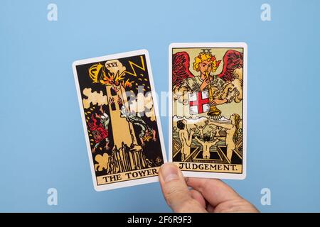 Main tenant deux cartes de tarot, la Tour et le jugement. Banque D'Images