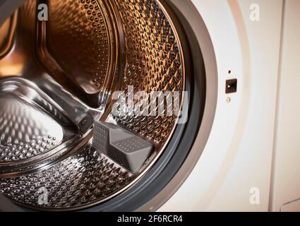 Tambour vide d'un lave-linge automatique aux couleurs vives Banque D'Images
