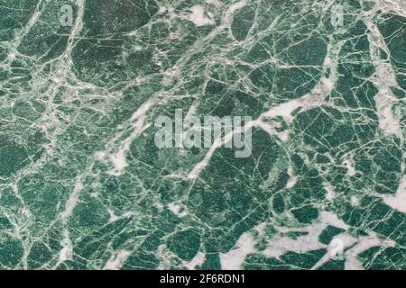 Texture de carreaux de pierre en malachite vert, motif blanc abstrait de fissures fond de plaque de marbre. Banque D'Images