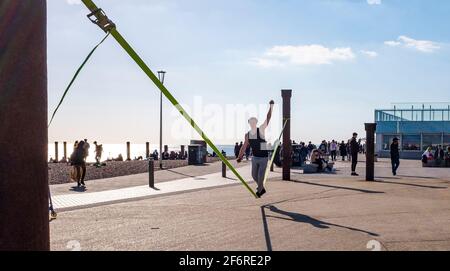 Brighton UK 2 avril 2021 - UN marcheur en corde raide profite du soleil de fin d'après-midi sur le front de mer de Brighton le vendredi Saint, mais les prévisions sont pour un temps beaucoup plus froid lundi avec de la neige prévue pour certaines régions du Royaume-Uni : Credit Simon Dack / Alay Live News Banque D'Images