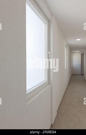 couloir dans le bâtiment, murs blancs et fenêtres Banque D'Images