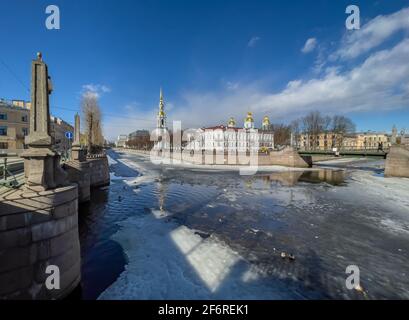 Russie, Saint-Pétersbourg, le 01 avril 2021 : clocher de la cathédrale navale de Saint-Nicolas en une journée ensoleillée de printemps, une dérive de glace sur Kryukov et Griboyedov Banque D'Images