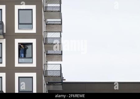 Menuisier d'installation d'une fenêtre haut dans un immeuble. Entrepreneur qui fixe une fenêtre en verre. Banque D'Images